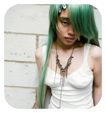 Green-haired model wearing a tangled charm necklace by Baby Toefu